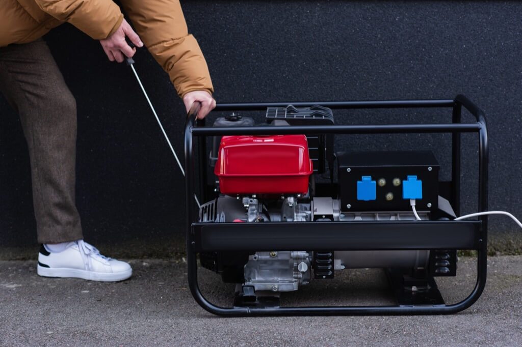 Portable generator sitting on a residential driveway ready for manual setup