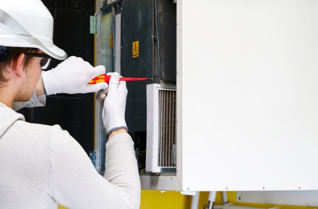 Technician performing furnace repair services while furnace stops working in a home.